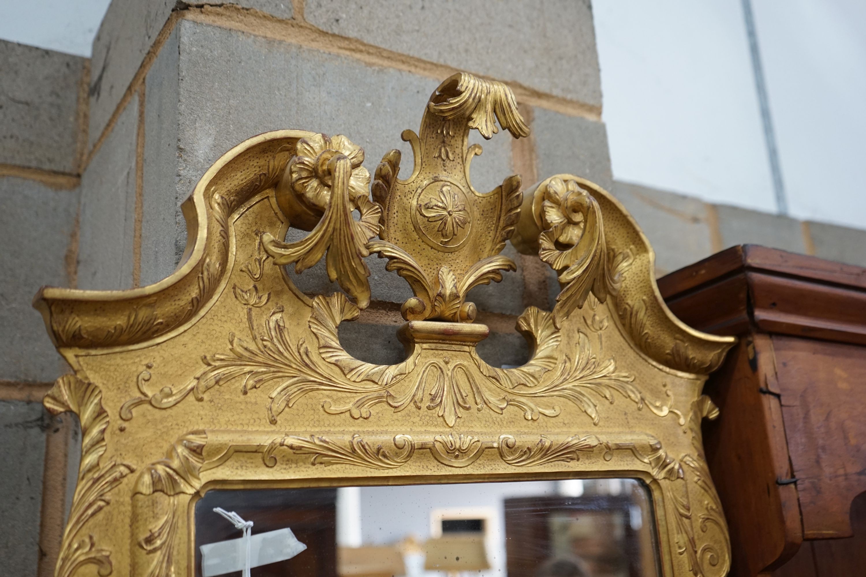 A pair of George II style carved giltwood wall mirrors, with scroll pediments, width 58cm, height 106cm